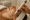close-up of a woman lying down with eyes closed while receiving a relaxing facial treatment using a modern skincare device.