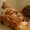 Woman with a headband enjoying a facial massage, her face glistening with treatment oils, in a spa setting.