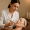 Aesthetician in a white coat performing a facial treatment with a handheld device on a client with hyperpigmentation.