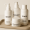 Minimalist set of skincare bottles labeled Serum, Cleanser, Toner, and Moisturizer, arranged on a beige tray.